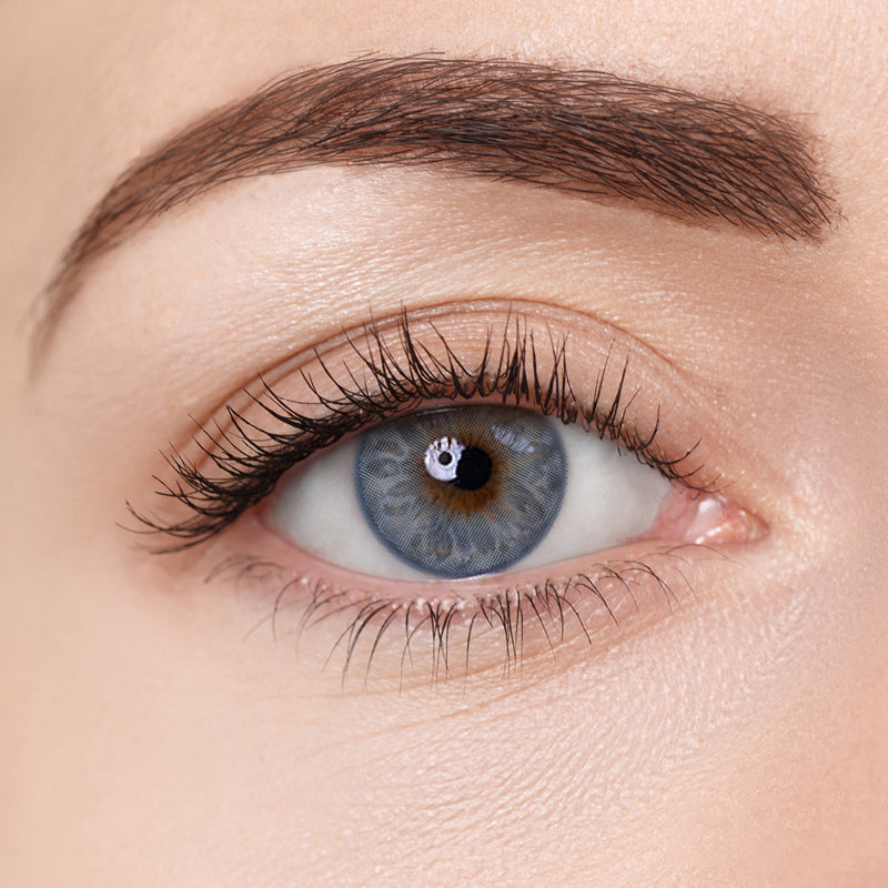 Close-up of an eye wearing Aura Lens Celestial Blue contact lens, showcasing a vibrant, sky-toned blue shade with a natural iris pattern — ideal for enhancing light or dark eyes.