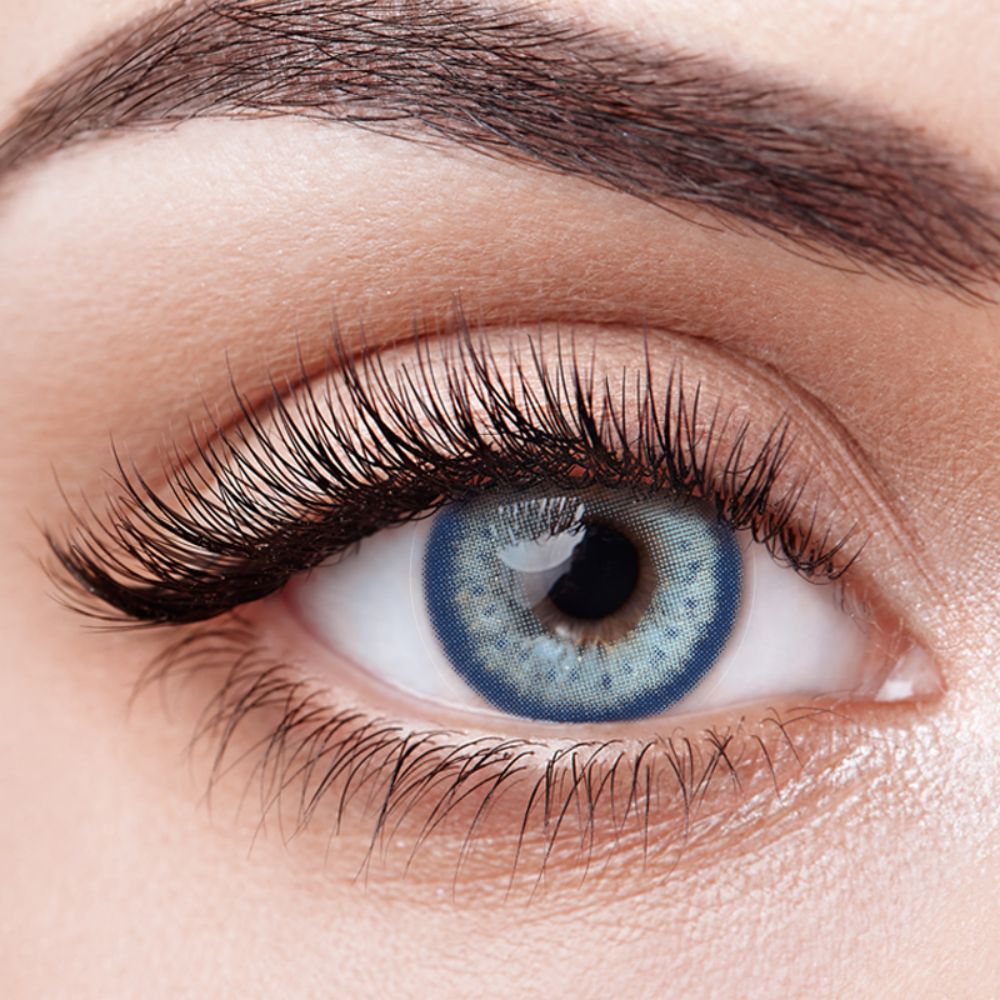 Close-up of a model wearing Aura Lens Electric Blue contact lenses, showcasing striking blue tones with a natural finish.