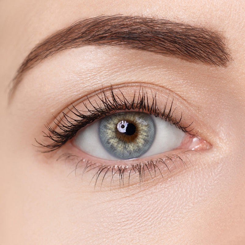 Close-up of eye wearing Aura Lens Glimmer Grey contact lens, showcasing soft grey tones with a natural, shimmering finish.