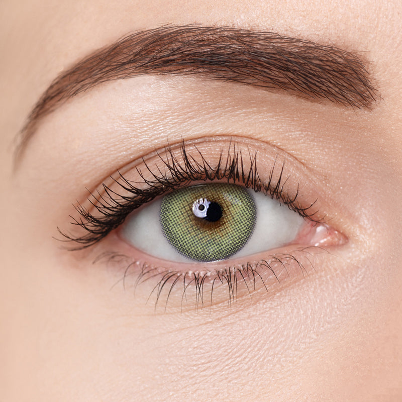 Close-up image of Aura Lens contact lens in Mystic Emerald shade, showing natural green tones designed to enhance eye color with a vibrant yet subtle look.